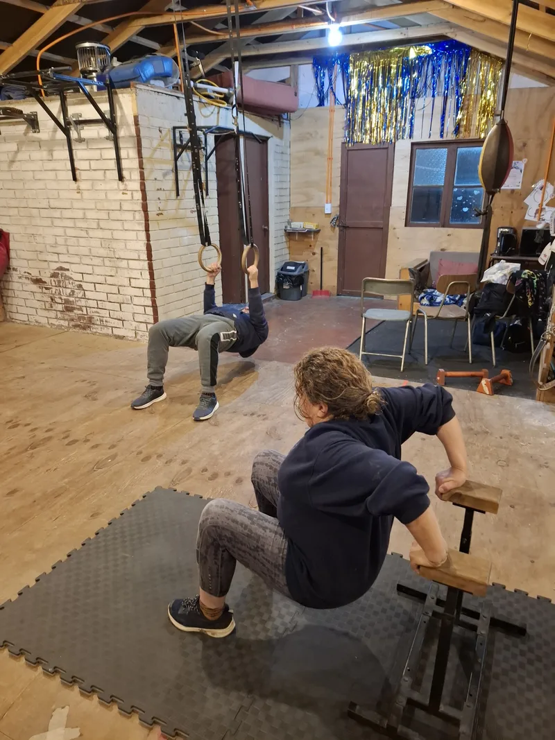 Dos personas entrenando con el peso de su cuerpo dentro de Elementos